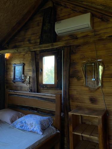 a bedroom with a bed in a wooden cabin at Bungalovi1885 Kosic in Danilovgrad