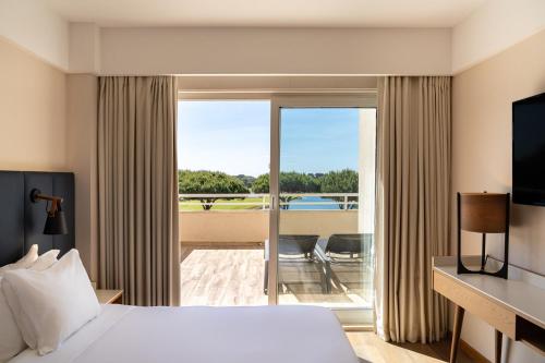 a hotel room with a bed and a balcony at Onyria Quinta da Marinha Hotel in Cascais