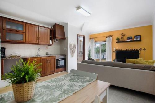 a living room with a couch and a kitchen at Porto Dinheiro Beach I in Lourinhã