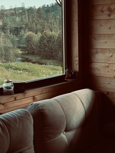 a couch in a room with a large window at Skroviste, Zlatibor-Vodice in Zlatibor