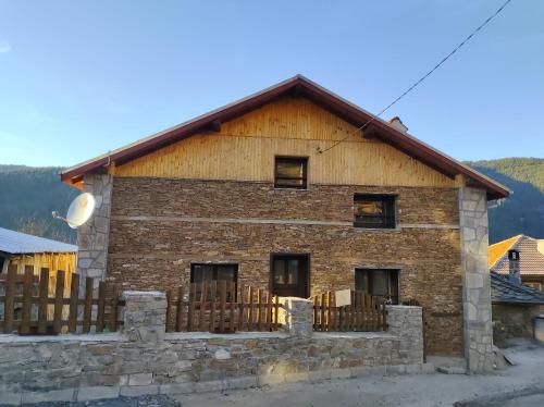 a brick building with a fence in front of it at Музикалната къща in Breze