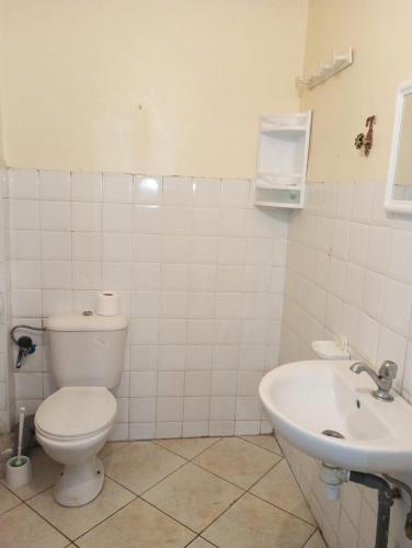 a white bathroom with a toilet and a sink at Elbernoussi in Casablanca