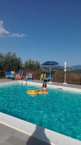 a child on a raft in a swimming pool at Agriturismo Villalta in Ponte Felcino