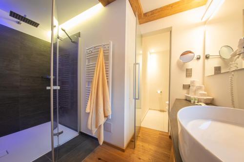 a bathroom with a shower and a tub and a sink at Mountainlodge Luxalpine in San Vigilio Di Marebbe