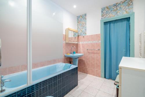 La salle de bains est pourvue d'une baignoire bleue et d'un lavabo. dans l'établissement 2P hyper-centre Nice, à Nice