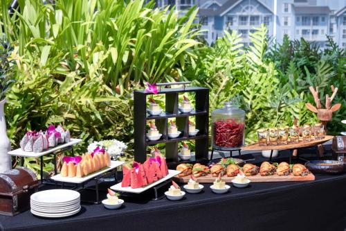 a table with various desserts and pastries on display at Howard Johnson by Wyndham Pattaya JC in Na Jomtien