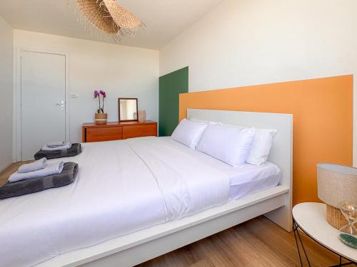 a bedroom with a large white bed with orange and green walls at Apartment Reysol in Agnone Bagni