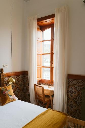 a bedroom with a bed and a window and a table at Dreamsea Boutique Experience in Moya