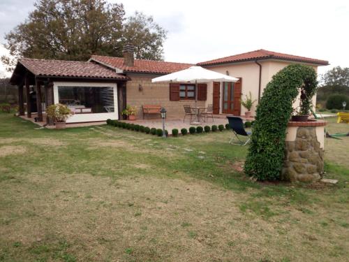 a small house with a patio and an umbrella at La Fratta in Sorano