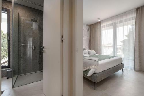 a bedroom with a bed and a glass shower at The Q Bliss - your new 4-star hideaway with a garage in Rovinj