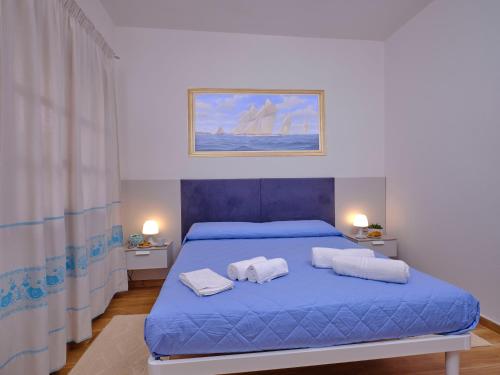 a bedroom with a blue bed with towels on it at GP34 Affittacamere in Olbia