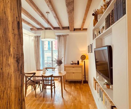 une salle à manger avec une table et une télévision dans l'établissement Charmant Appartement au cœur de Montmartre!, à Paris