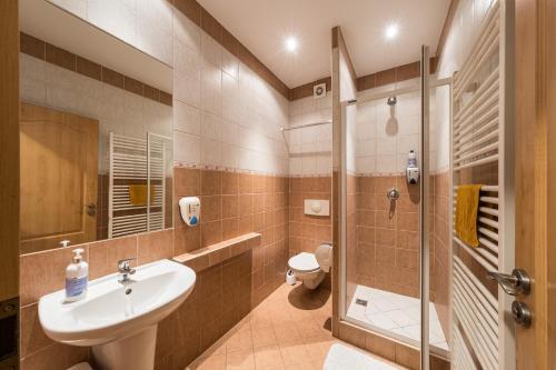 a bathroom with a sink and a shower at Penzion Kozí Horka u Brněnské přehrady in Brno
