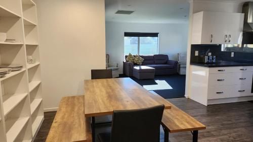a kitchen and living room with a table and a couch at OakTree Entire Holiday Home, Sleeps 8 to12 in Rotorua