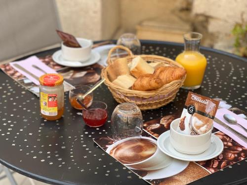 einen Tisch mit einem Frühstück mit Kaffee und Gebäck darauf in der Unterkunft Domaine la coquillade in Autignac
