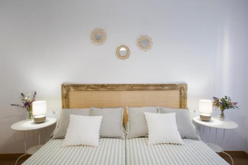 a white bedroom with a bed with two tables at Apartamento turístico Ana, con garaje y bonitas vistas in Arróniz