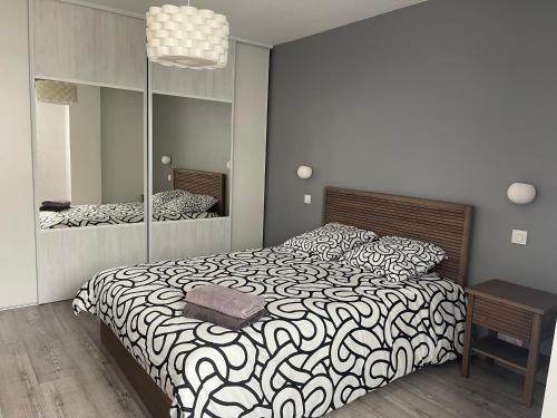 une chambre avec un grand lit et un miroir dans l'établissement Bienvenue à la Casa Familia !, à Sérignan