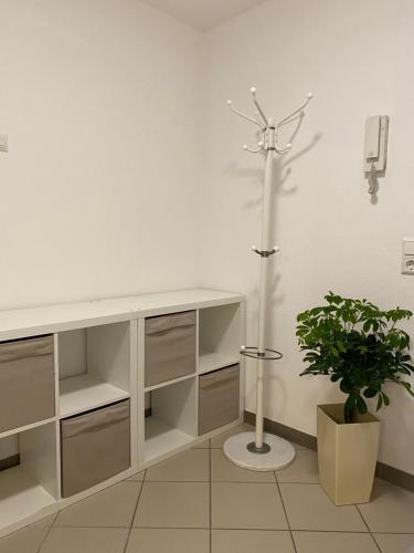 a white room with a light pole and a plant at Einzimmer Apartment in Niefern-Öschelbronn