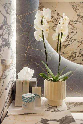 a vase with white flowers sitting on a table at Hotel Villa Domizia in Porto Santo Stefano
