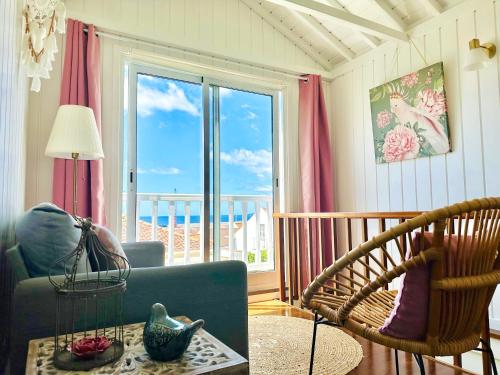 a living room with a couch and a chair and a window at Cottage at FLAMINGAS PLACE in Lajes do Pico
