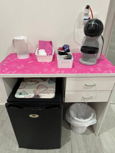 a pink desk with a counter top with a coffee maker at Glicine in Parghelia