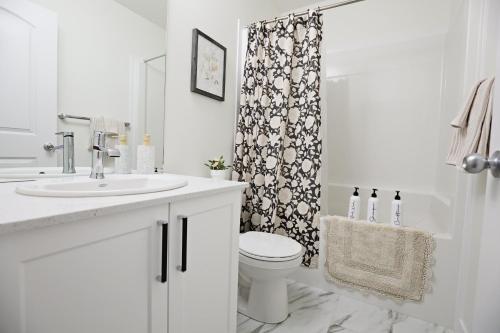 a bathroom with a sink and a toilet and a shower at Elegant Escape with King Bed, Long Stays, WEM, Disney in Edmonton