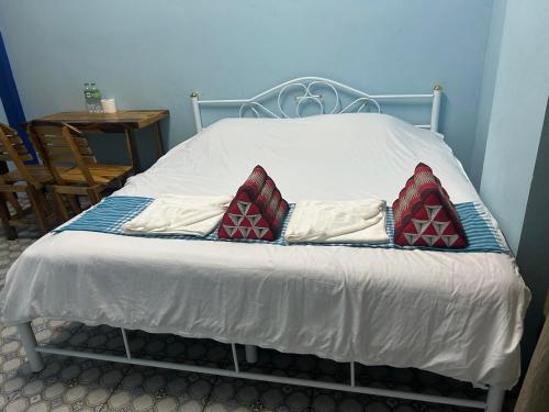 a bed with two pillows on it in a room at Noot's Guesthouse in Kanchanaburi