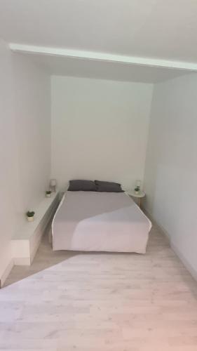 - une chambre blanche avec un lit et un mur blanc dans l'établissement La Normandie, à Saint-Pierre-du-Val