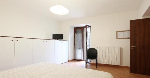 - une chambre blanche avec un lit et une chaise dans l'établissement Monteverde, à Latronico