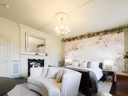 a bedroom with two beds and a couch and a chandelier at Quob Park Old House Hotel & Spa in Fareham
