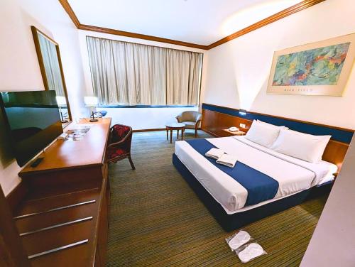 a hotel room with a bed and a desk at Park Avenue Hotel Sungai Petani in Sungai Petani