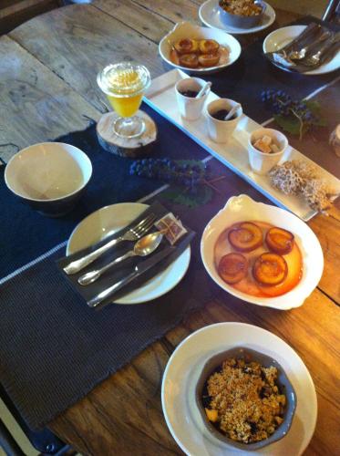 een tafel met borden eten op een houten tafel bij Suites de Campagne Les Eydieux, petits déjeuners inclus in Saint-Angel