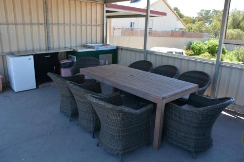 a wooden table and chairs on a patio at Augusta Courtyard Motel in Port Augusta