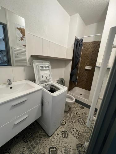une salle de bain blanche avec un lavabo et des toilettes dans l'établissement Appartement climatisé avec place de parking privé, à La Grande Motte