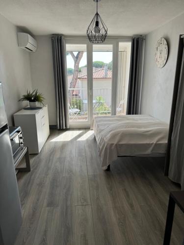 une chambre avec un lit et une grande fenêtre dans l'établissement Appartement climatisé avec place de parking privé, à La Grande Motte