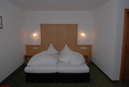 a room with a bed with white pillows at Bacherhof in Sankt Anton am Arlberg