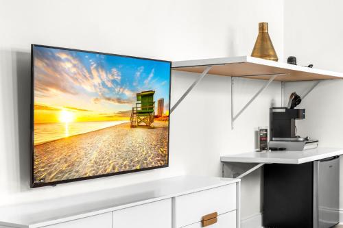 a tv on a white wall in a living room at Luxuri Suites in Miami Beach