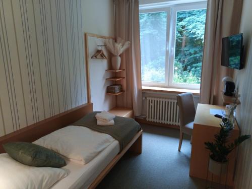 a small bedroom with a bed and a window at Hotel Damme in Damme