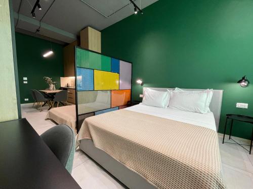 a bedroom with a large bed and a green wall at Ambassador Skyline Apartments in Tirana