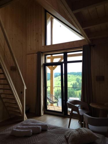 a bedroom with a large window and a bed in a room at Шале Green Land in Bukovel