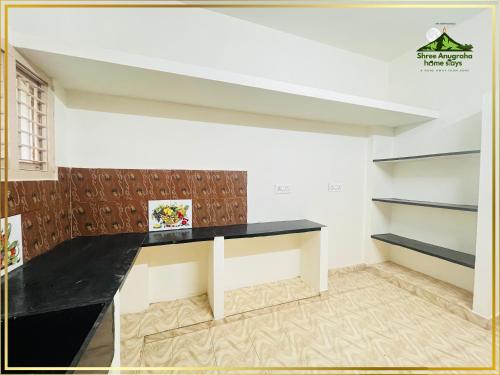 a room with a black counter and shelves at Shree Anugraha Home Stays in Tiruvannāmalai