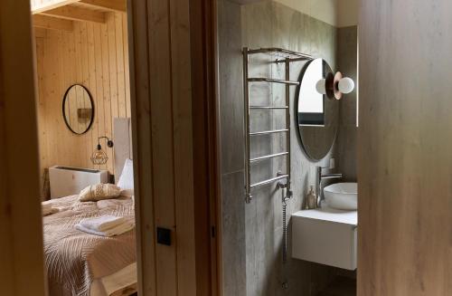 a bathroom with a sink and a mirror and a bed at Шале Green Land in Bukovel