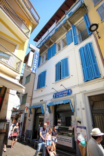a group of people walking in front of a building at la Strecia in Stresa