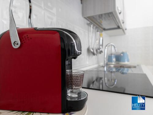 a red toaster sitting on a kitchen counter with a glass at CALALUNGA PIETRAGRANDE - Exclusive Shoreline Haven in Montepaone Lido