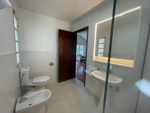 a bathroom with two toilets and a sink and a mirror at Villa Carmiña in Puerto del Carmen