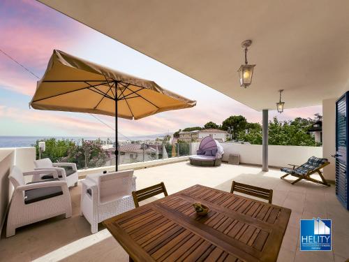 a patio with a table and chairs and an umbrella at CALALUNGA PIETRAGRANDE - Exclusive Shoreline Haven in Montepaone Lido