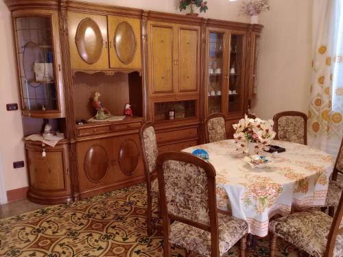 a dining room with a table and a large wooden cabinet at casa vacanze marinela in Casarano