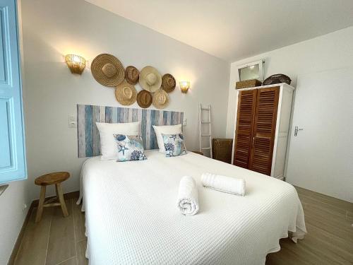 une chambre avec un lit blanc avec des serviettes dessus dans l'établissement Escale Romana, à La Ciotat