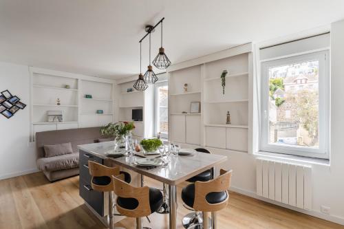 une cuisine et une salle à manger avec une table et des chaises dans l'établissement Instant Détente - Appt à 50 m de la plage, à Pléneuf-Val-André