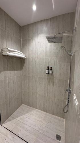 a bathroom with a shower with two bottles in it at شقة فاخرة من 3 غرف بكمباوند الماجدية in Riyadh